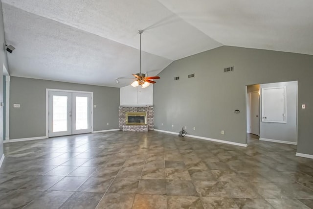 unfurnished living room with tile flooring, ceiling fan, a fireplace, a textured ceiling, and high vaulted ceiling