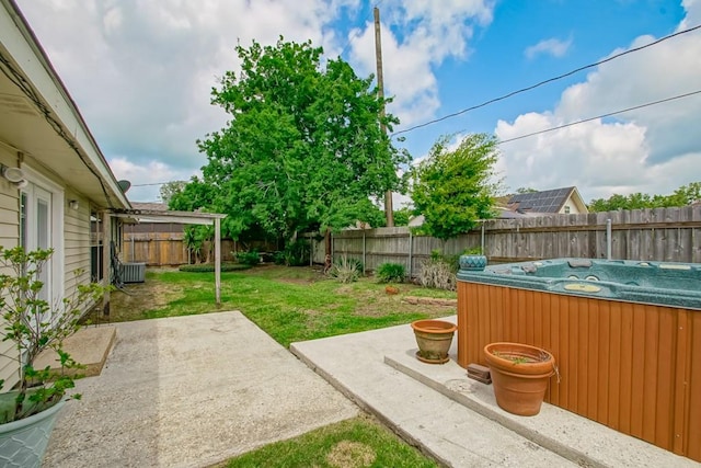 view of yard with a patio, a hot tub, and central air condition unit