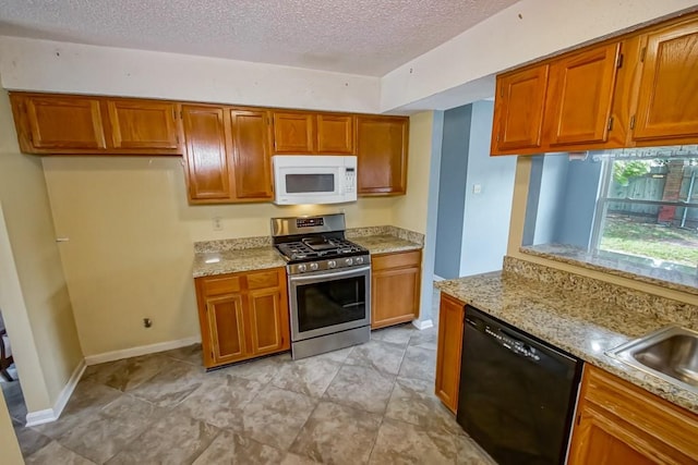 kitchen featuring dishwasher, a textured ceiling, stainless steel range with gas cooktop, and light tile floors