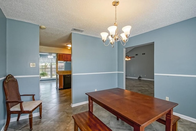 tiled dining room featuring a textured ceiling and an inviting chandelier