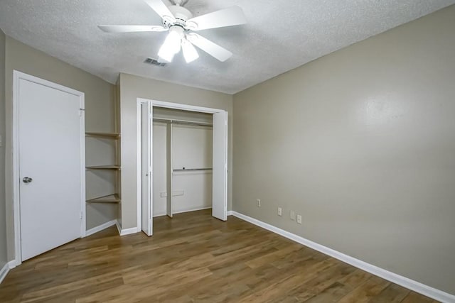 unfurnished bedroom featuring ceiling fan, a textured ceiling, and wood-type flooring