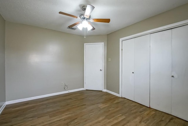 unfurnished bedroom with hardwood / wood-style flooring, a closet, and ceiling fan