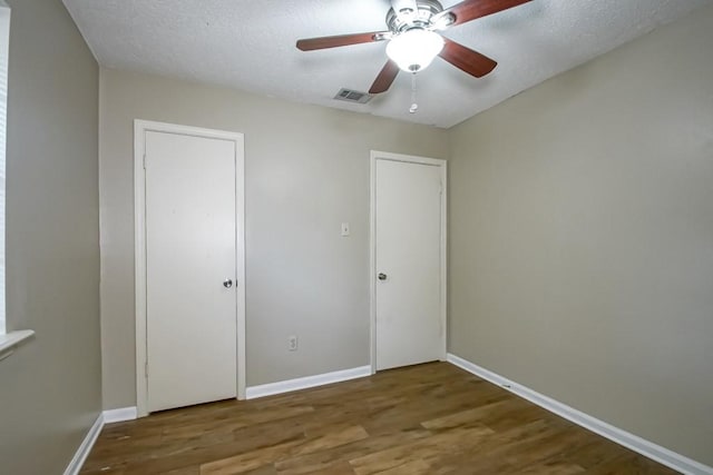 unfurnished bedroom featuring a textured ceiling, wood-type flooring, and ceiling fan