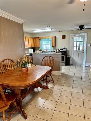 dining space featuring light tile flooring, ornamental molding, plenty of natural light, and ceiling fan