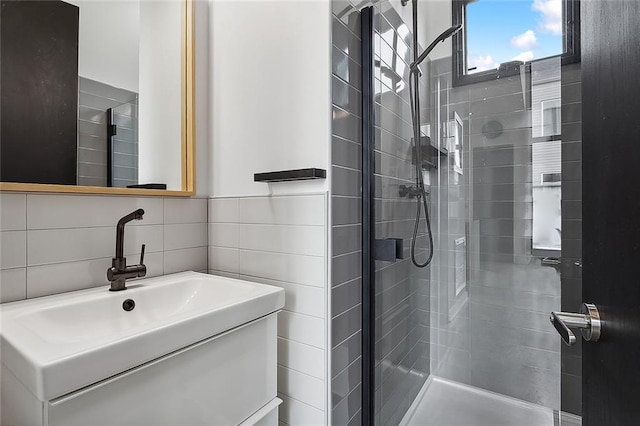 bathroom with vanity, tile walls, and a shower with shower door