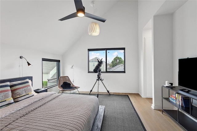 bedroom with high vaulted ceiling, ceiling fan, and light wood-type flooring