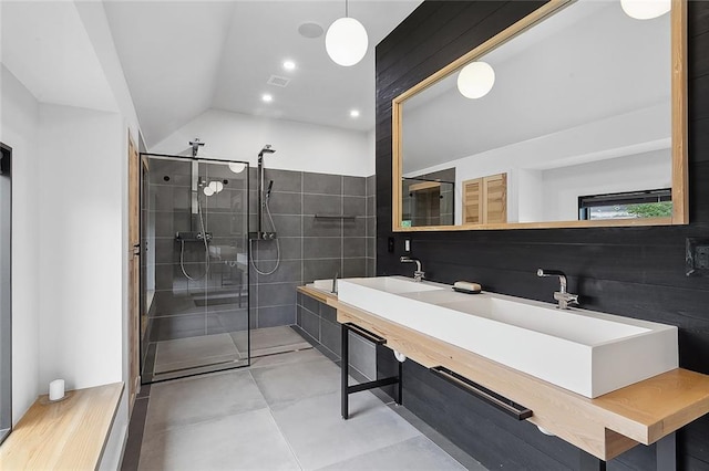 bathroom featuring tile floors, lofted ceiling, vanity, and a shower with door