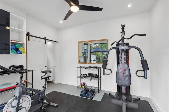 workout area featuring ceiling fan and a barn door