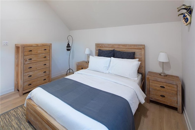 bedroom featuring hardwood / wood-style floors and vaulted ceiling