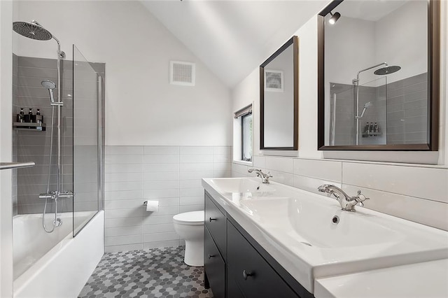 full bathroom with tile walls, lofted ceiling, shower / bath combination with glass door, and tile flooring