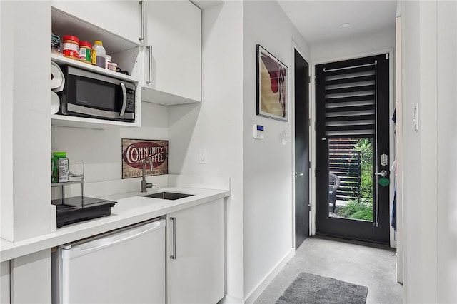 kitchen with white cabinets, stainless steel microwave, white dishwasher, and sink