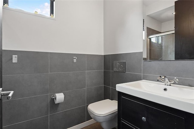 bathroom with tile walls, backsplash, toilet, and vanity with extensive cabinet space