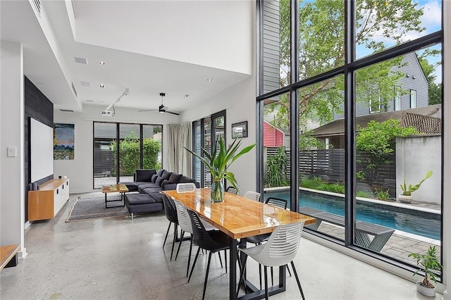 dining space with ceiling fan and a towering ceiling