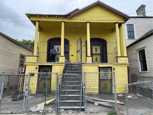 view of front facade featuring a fenced front yard, a gate, and stucco siding