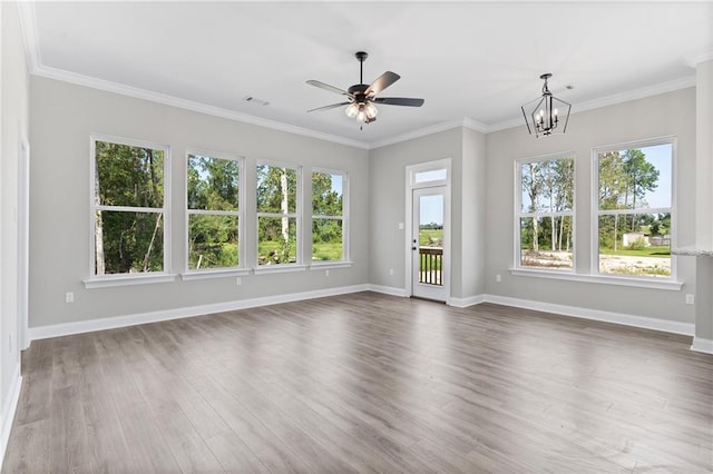 interior space featuring ceiling fan with notable chandelier, crown molding, dark hardwood / wood-style flooring, and plenty of natural light