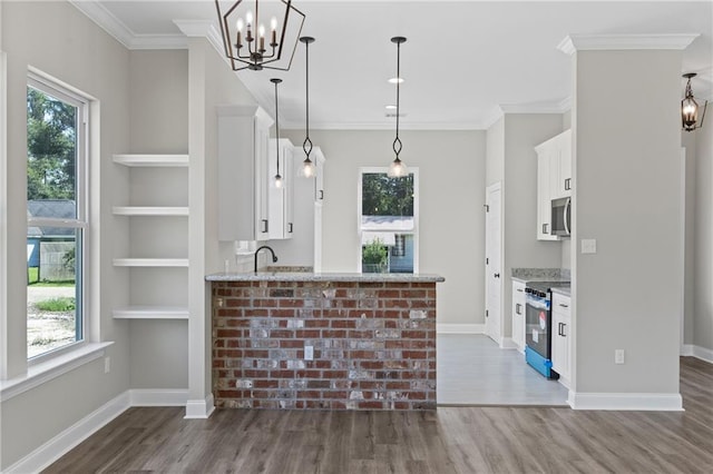 kitchen featuring hanging light fixtures, white cabinets, stainless steel appliances, a center island with sink, and sink