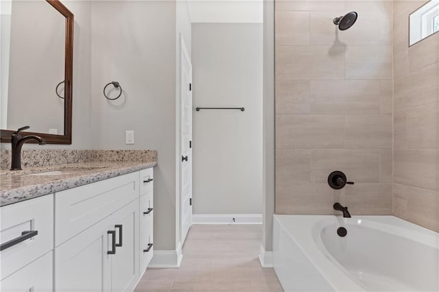 bathroom featuring tiled shower / bath combo, tile patterned flooring, and vanity