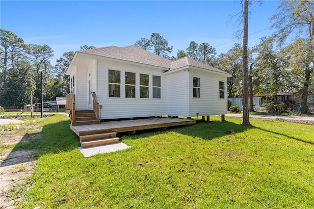 rear view of house featuring a deck and a yard