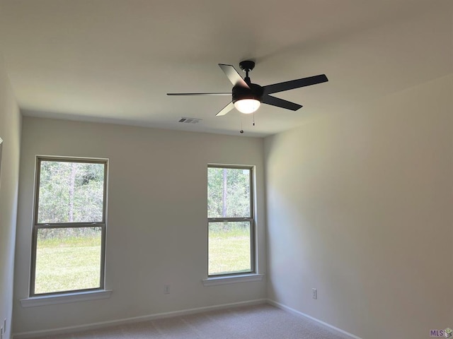 carpeted spare room with ceiling fan and a healthy amount of sunlight