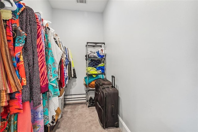 spacious closet featuring light colored carpet