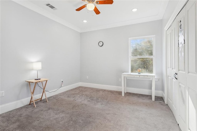 spare room featuring ceiling fan, carpet floors, and crown molding