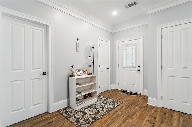 foyer entrance featuring hardwood / wood-style flooring and crown molding