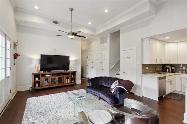 living room with sink, dark wood-type flooring, ceiling fan, and a raised ceiling