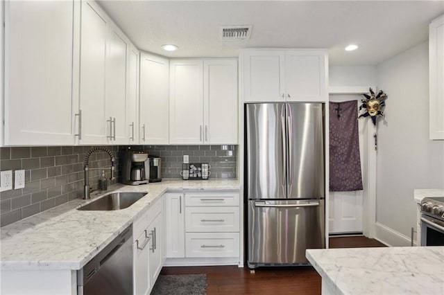 kitchen with dark hardwood / wood-style flooring, sink, backsplash, and stainless steel appliances