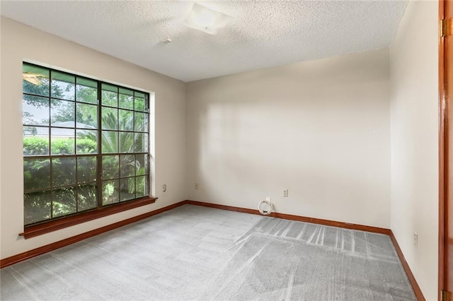 carpeted empty room featuring a textured ceiling