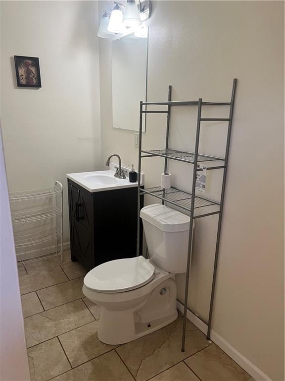 bathroom featuring tile floors, vanity, toilet, and an inviting chandelier