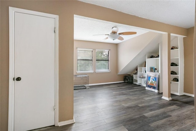 additional living space with ceiling fan, dark hardwood / wood-style flooring, and a textured ceiling