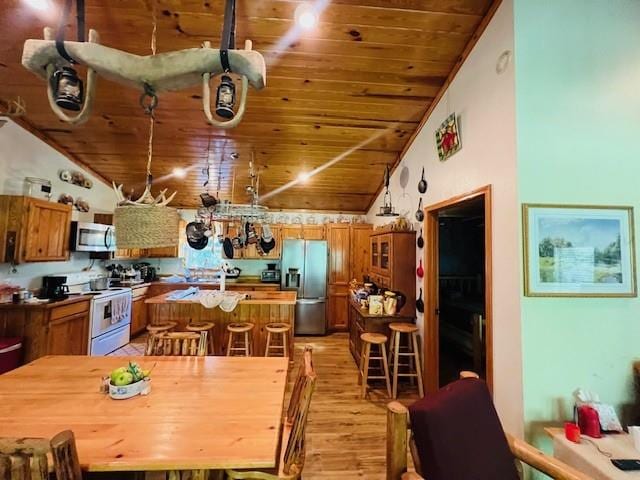 dining room featuring light wood-type flooring, lofted ceiling, and wooden ceiling