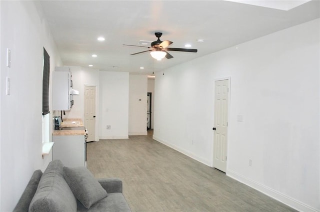 living room featuring ceiling fan and light hardwood / wood-style flooring