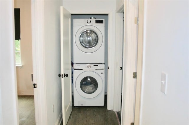 clothes washing area featuring stacked washer and clothes dryer and dark hardwood / wood-style flooring