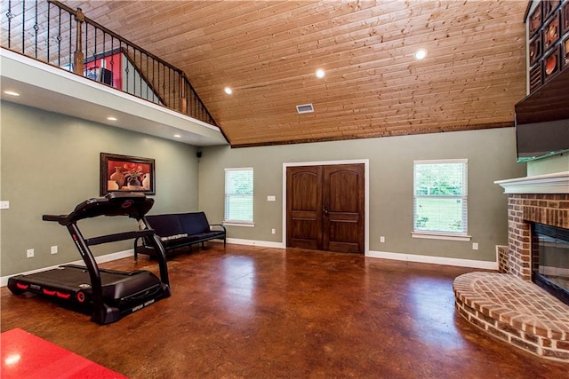 workout area with high vaulted ceiling and a fireplace