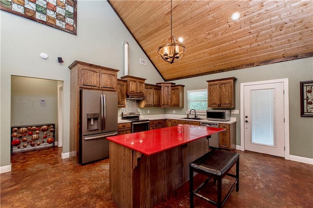 kitchen with tasteful backsplash, stainless steel appliances, an inviting chandelier, a kitchen island, and high vaulted ceiling