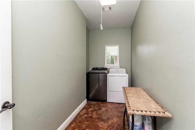 clothes washing area with washer and dryer and a textured ceiling