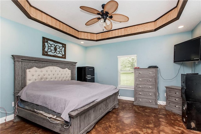 bedroom with ceiling fan and a tray ceiling