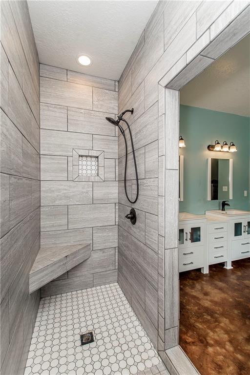 bathroom with tiled shower and oversized vanity