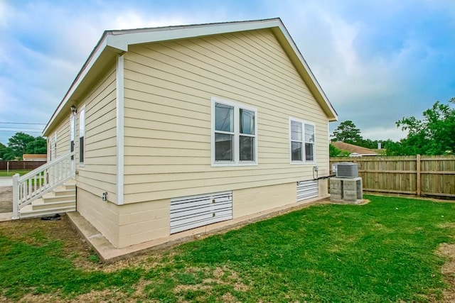 view of side of property with a yard and central air condition unit