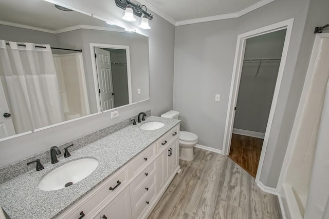 bathroom with ornamental molding, toilet, double sink vanity, and hardwood / wood-style floors