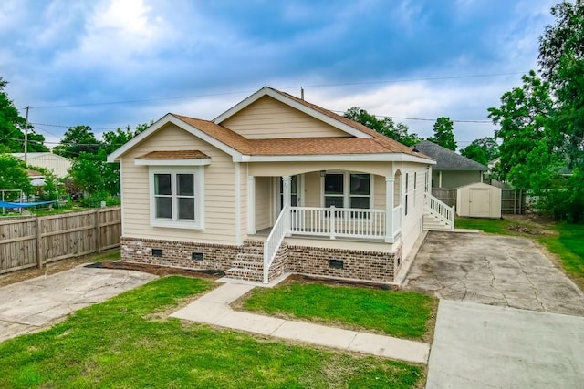 bungalow with a porch and a storage shed