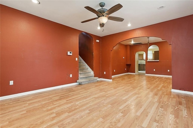 unfurnished living room featuring ceiling fan and light hardwood / wood-style floors