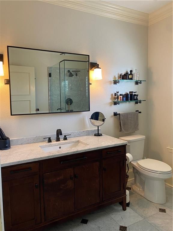 bathroom featuring an enclosed shower, tile patterned floors, toilet, vanity, and ornamental molding