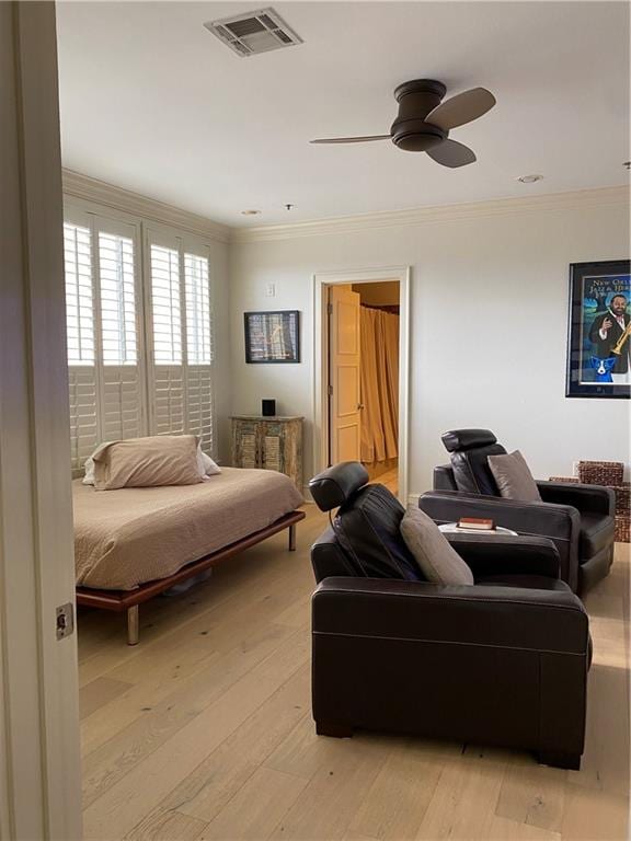 bedroom featuring ornamental molding, light wood-type flooring, and ceiling fan