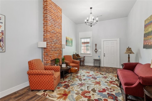 living room with brick wall, dark hardwood / wood-style flooring, and a chandelier