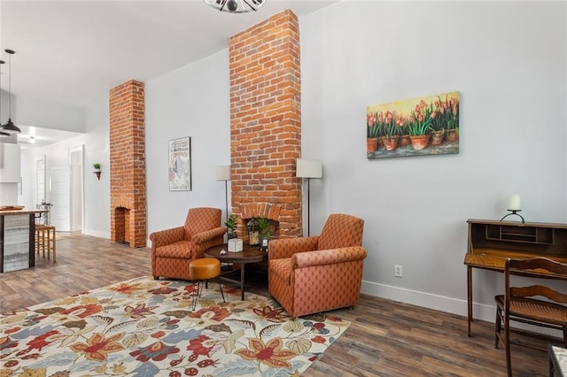 living room with brick wall and dark hardwood / wood-style floors