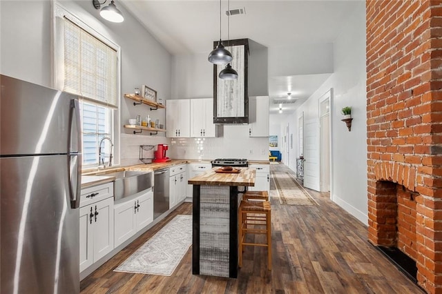 kitchen featuring white cabinetry, wood counters, stainless steel appliances, dark hardwood / wood-style floors, and sink