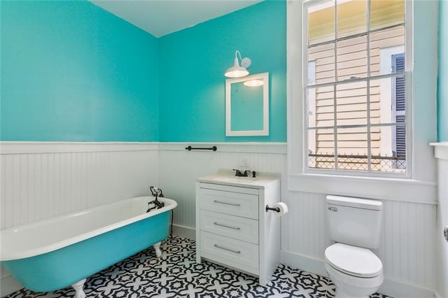 bathroom featuring vanity, toilet, tile floors, and a bathing tub