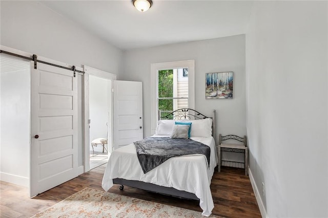 bedroom with hardwood / wood-style floors and a barn door